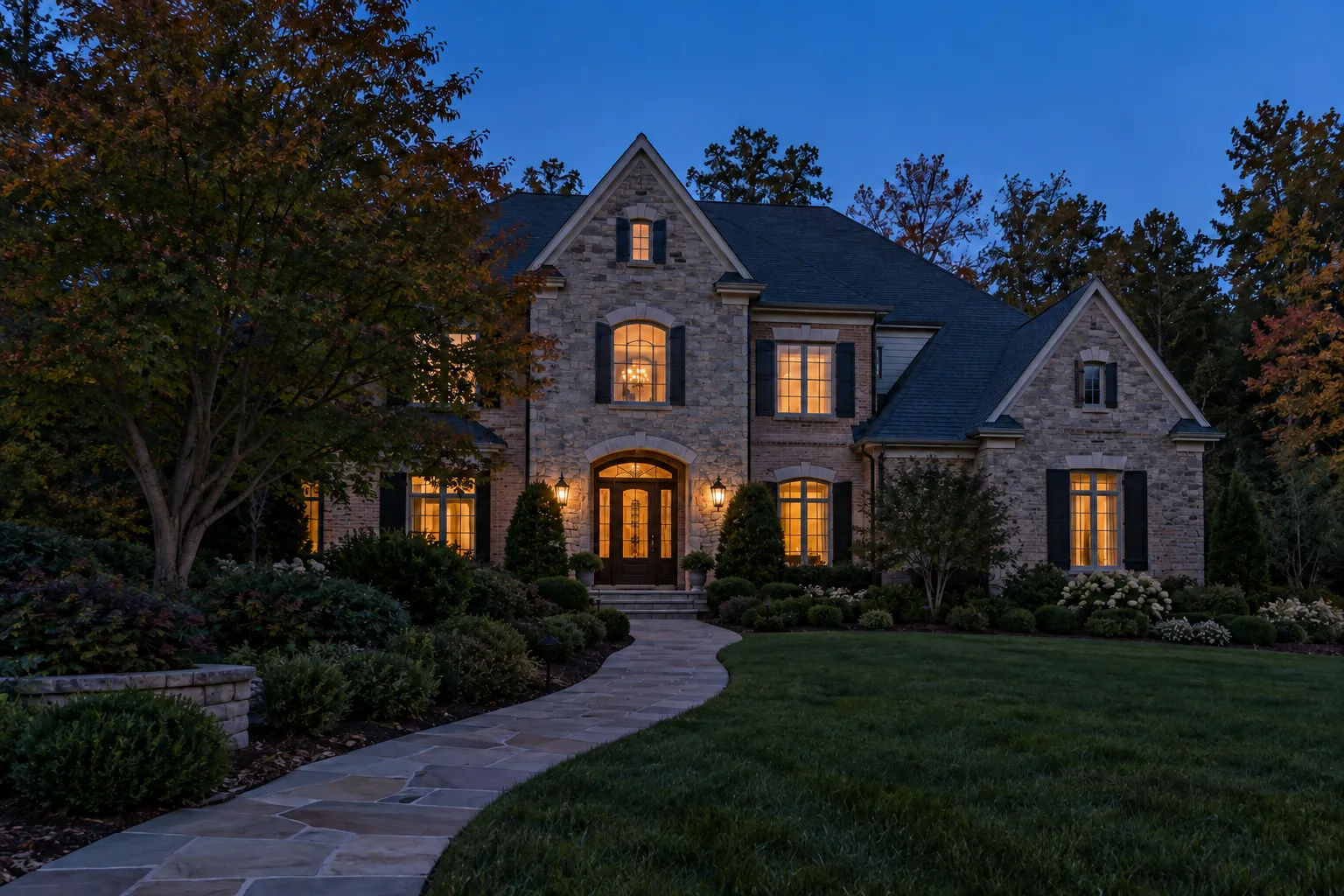 home at blue hour before landscape lighting, with only interior lights and porch lanterns