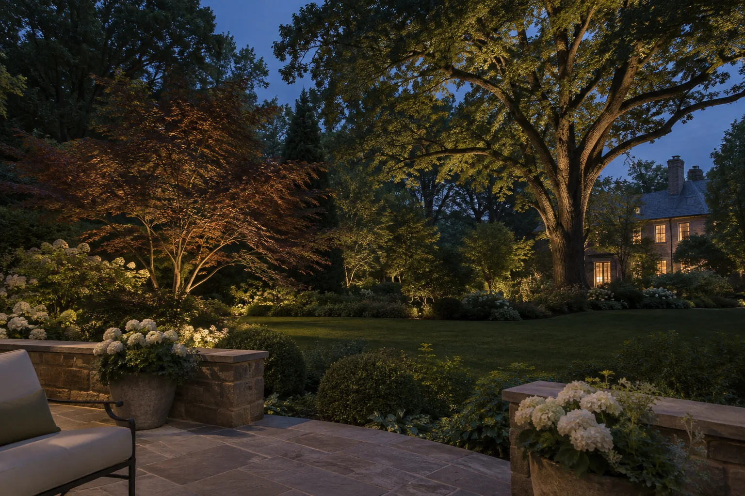 Mature garden with softly illuminated branches and layered planting at twilight